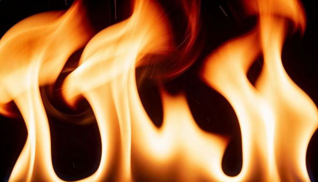 Flickering Flames Dancing Against Dark Backdrop with Amber Embers and Flowing Tongues