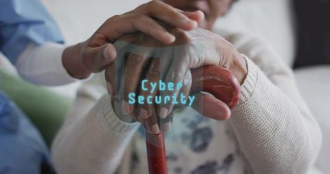 Caregiver holding elderly hand on cane while highlighting cybersecurity concept