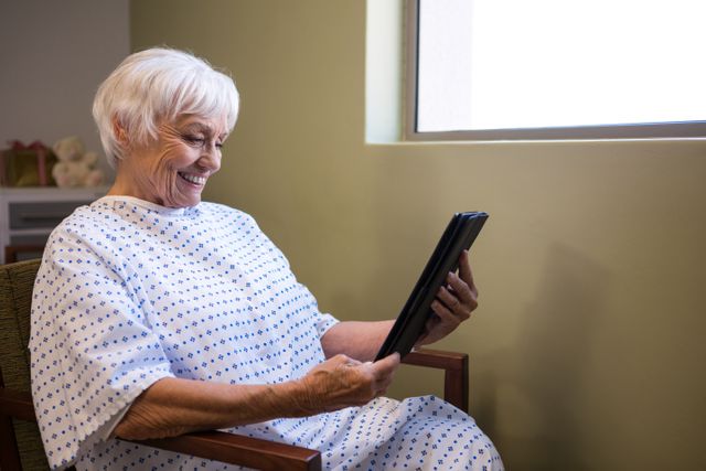 Senior patient using digital tablet to video chat in hospital