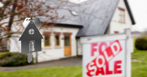 Silver Key with House Symbol by Sold Real Estate Sign