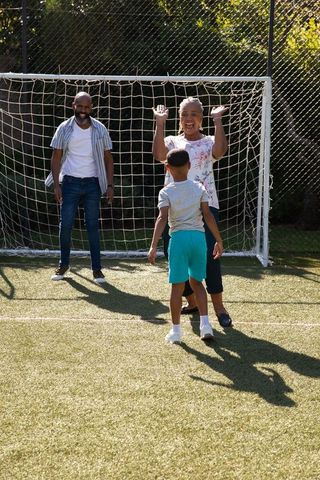Multigenerational Family Celebrating with Boy by Soccer Goal