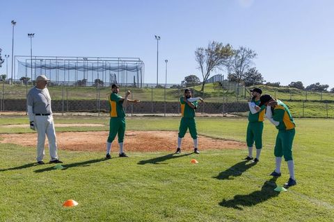 Amateur Baseball Team Warming Up on Infield with Coach Leading Stretch Routine