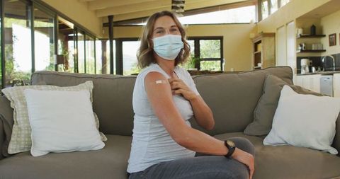 Pregnant woman celebrating vaccination achievement at home