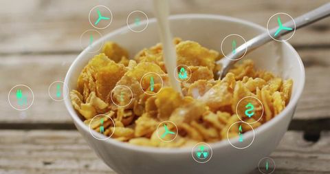 Pouring Milk Over Crunchy Cornflake Cereal with Floating Green Eco Icons, Breakfast Closeup