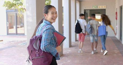 Smiling Asian Teen Girl at School with Friends in Background - Download Free Stock Images Pikwizard.com