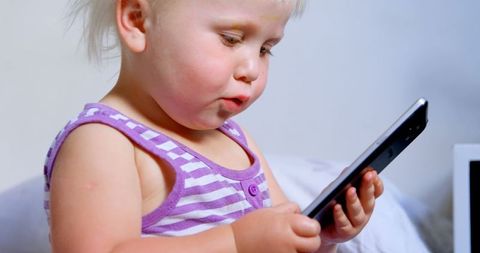 Young Girl Engaging with Smartphone Technology Indoors