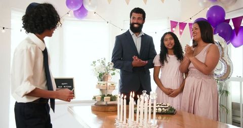 Family Celebrating Bar Mitzvah with Candle Lighting Ceremony at Home