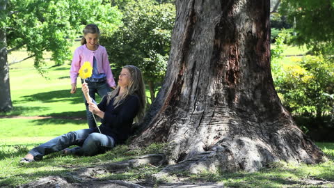 Mother and Daughter Bonding Under Tree in Park