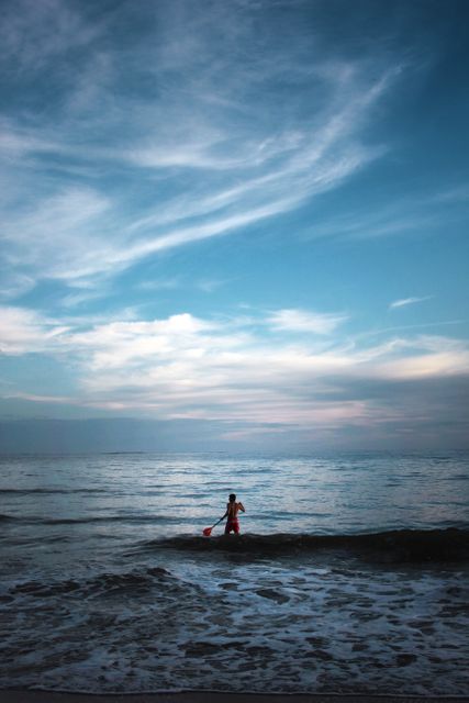 Person Standing in Ocean at Sunset under Dramatic Sky - Download Free Stock Images Pikwizard.com