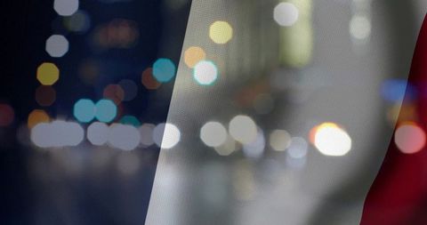 Waving french tricolor fabric over urban night bokeh with neon light glow