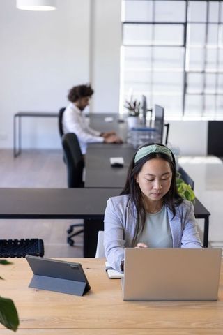 Focused Professional Working in Modern Minimalist Office with Laptop