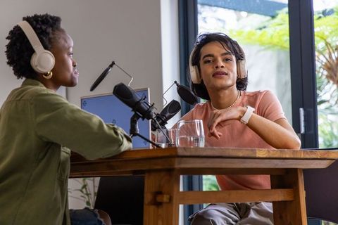 Diverse co-hosts recording conversational podcast at home studio with professional gear