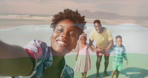 Smiling Woman Taking Selfie on Beach Vacation with Family