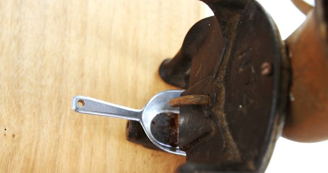 A rusty iron and a metal measuring spoon rest on a wooden surface, with copy space. Rust on the items suggests neglect or the passage of time, evoking a sense of abandonment or disuse.