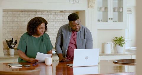 Couple Managing Finances at Kitchen counter on a Laptop