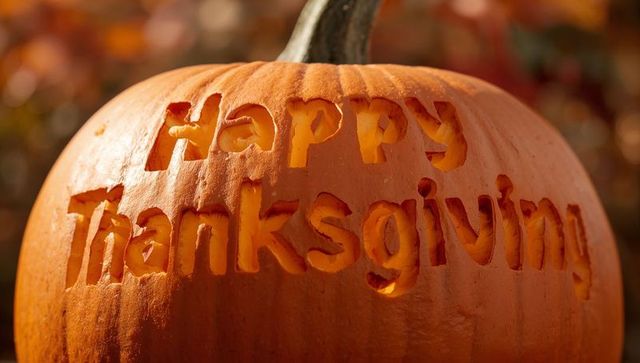 Carved pumpkin saying happy thanksgiving closeup golden hour autumn decor