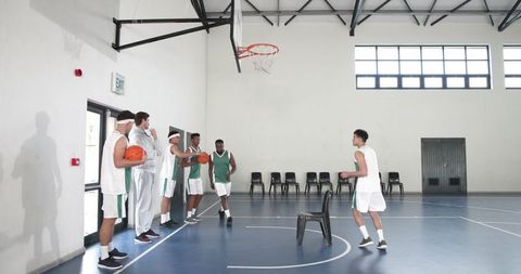 Diverse basketball team practicing on indoor court