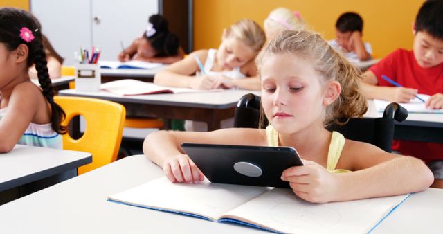 Focused students in classroom using tablet and writing - Download Free Stock Images Pikwizard.com