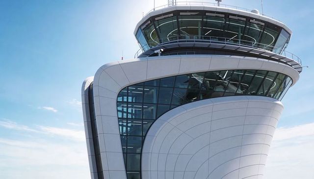 Commanding modern airport control tower overlooking runways with wraparound glass cab
