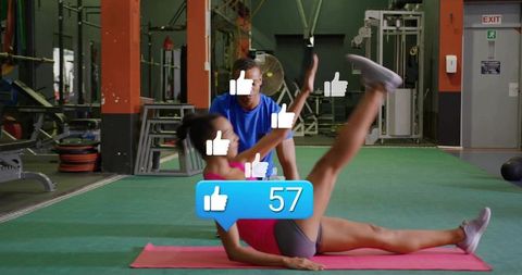 Female athlete performing leg raise on mat while trainer coaching with social likes overlay