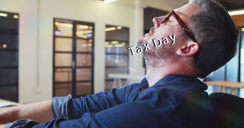 Overwhelmed man facing tax day deadlines at office
