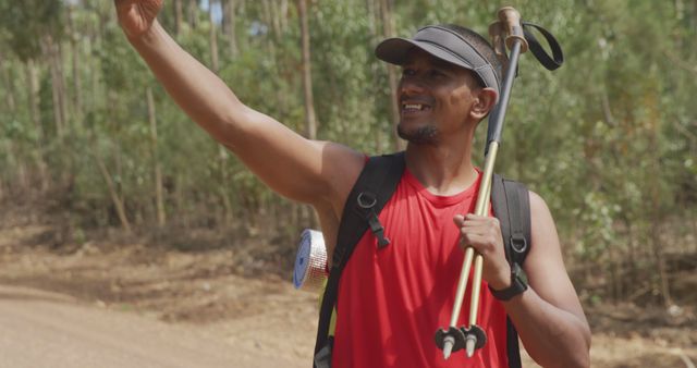 Man in red tank top with hiking gear taking a selfie in the forest - Download Free Stock Images Pikwizard.com