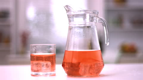 Refreshing Juice and Ice Cubes in Glass and Jug
