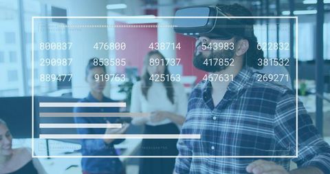 Man wearing VR headset manipulating holographic dashboard in modern office collaborative workspace