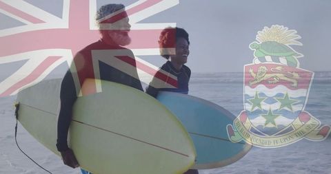 Couple Walking to Cayman Islands' Shore Carrying Surfboards