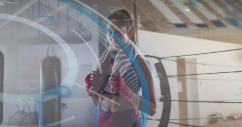 Female boxer adjusting red hand wraps in ring with towel and blue training overlay