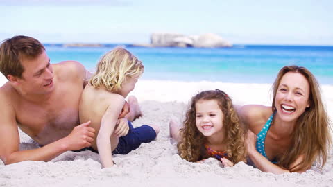 Laughing Family Enjoying Time on Sunny Beach Vacation
