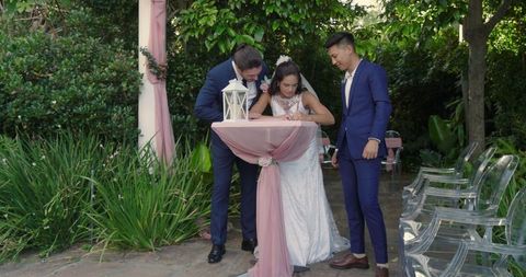 Bride and groom signing wedding certificate in garden ceremony