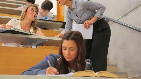 University Students Studying in Lecture Hall with Professor Guidance