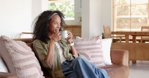 African american woman relaxing on sofa with coffee mug