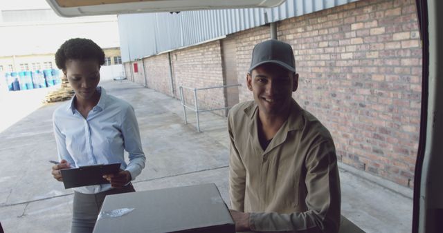 Delivery Personnel Handling Package with Clipboard Outdoors - Download Free Stock Images Pikwizard.com