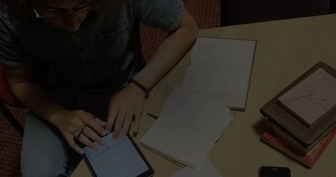 Student Using Tablet for Study in Casual Workspace Setting