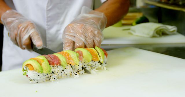 Chef Slicing Fresh Sushi Roll with Seared Fish and Avocado in Commercial Kitchen - Download Free Stock Images Pikwizard.com