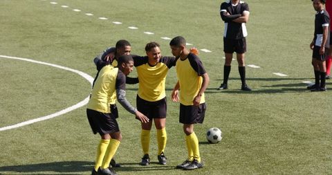 Soccer Players Celebrating Victory on Field with High Fives