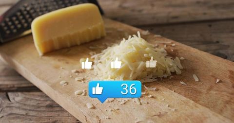 Rustic shredded cheese on wooden cutting board with grater and social media likes overlay