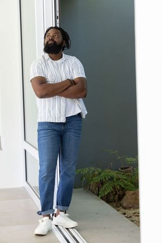 African american man leaning in doorway casual style minimal interior lifestyle portrait
