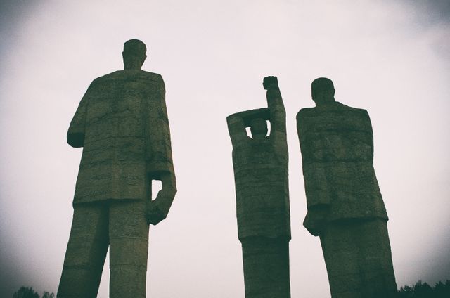 Silhouettes of Stone Statues Under Pale Sky Creating an Eerie Atmosphere - Download Free Stock Photos Pikwizard.com