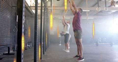 Group functional fitness training with medicine balls in modern gym