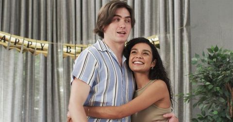 Interracial Couple Embracing During Birthday Celebration