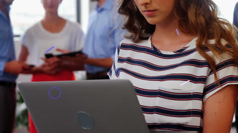 Young Professional with Laptop in Collaborative Office Environment
