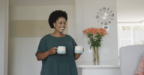 Joyful Woman Serving Hot Beverages in Contemporary Home