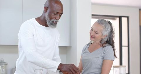 Senior couple sharing warm kitchen morning preparing breakfast together with gentle smiles
