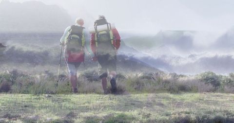 Hiking partners trekking with backpacks along serene coastline