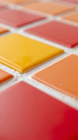 Showing Close-up Vertical Video of Vibrant Yellow Tile in Red Orange Mosaic Backsplash