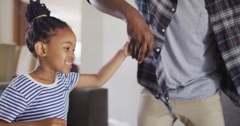 Joyful Daughter Dancing with Father in Living Room