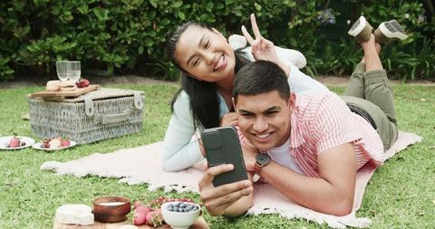 Joyful Couple Taking Selfie During Relaxing Picnic in Nature